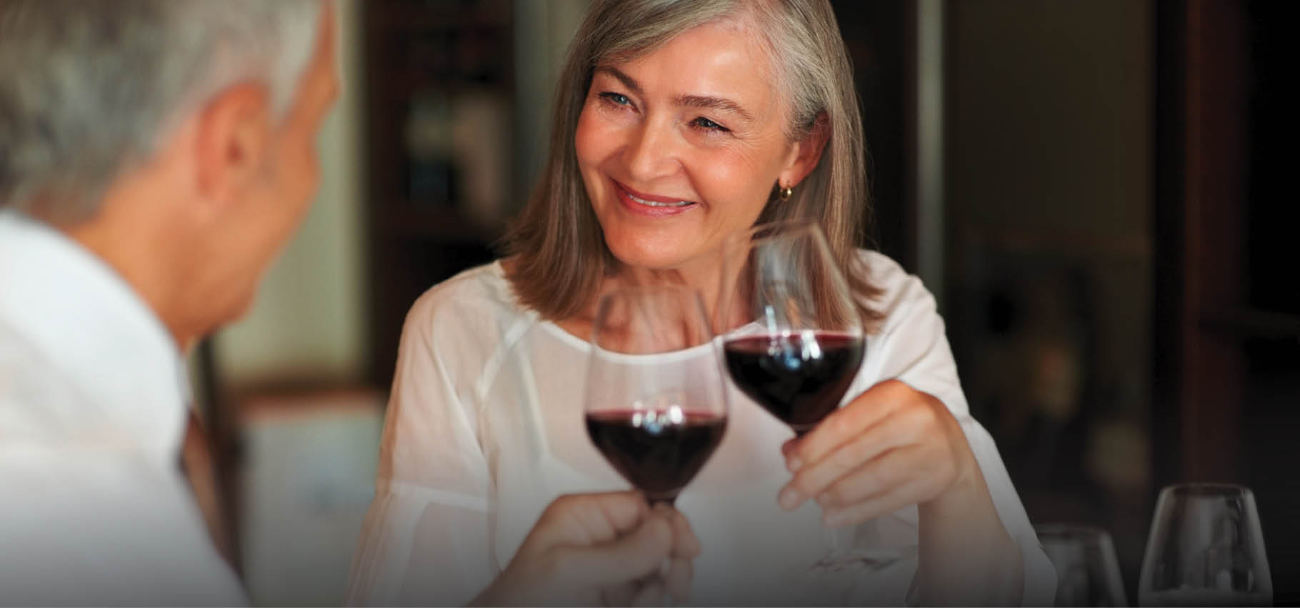 Elderly woman toasting wine with her husband at a smart restaurant