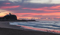 Sunrise at Nobbys Beach and Lighthouse famous landmarks in the harbour city of Newcastle NSW Australia